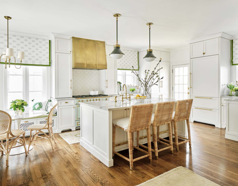 Example of a large classic medium tone wood floor kitchen design in Austin with shaker cabinets, white cabinets, marble countertops, white backsplash, ceramic backsplash and an island