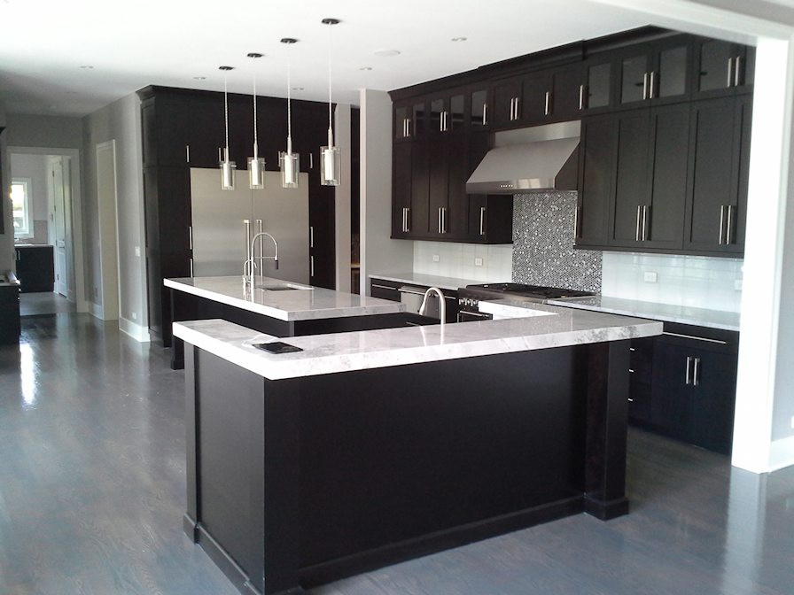 Eat-in kitchen - large transitional u-shaped light wood floor and gray floor eat-in kitchen idea in Chicago with an undermount sink, recessed-panel cabinets, black cabinets, quartz countertops, white backsplash, ceramic backsplash, stainless steel appliances, two islands and white countertops