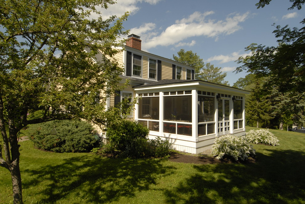 Inspiration for a large traditional side yard screened-in verandah in Portland Maine with a roof extension.
