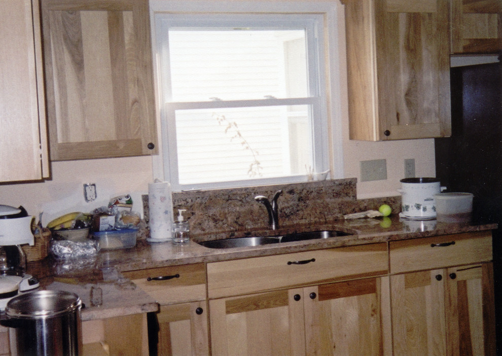 Small transitional galley ceramic tile and brown floor kitchen photo with an undermount sink, recessed-panel cabinets, light wood cabinets, marble countertops, brown backsplash, marble backsplash, black appliances, no island and brown countertops