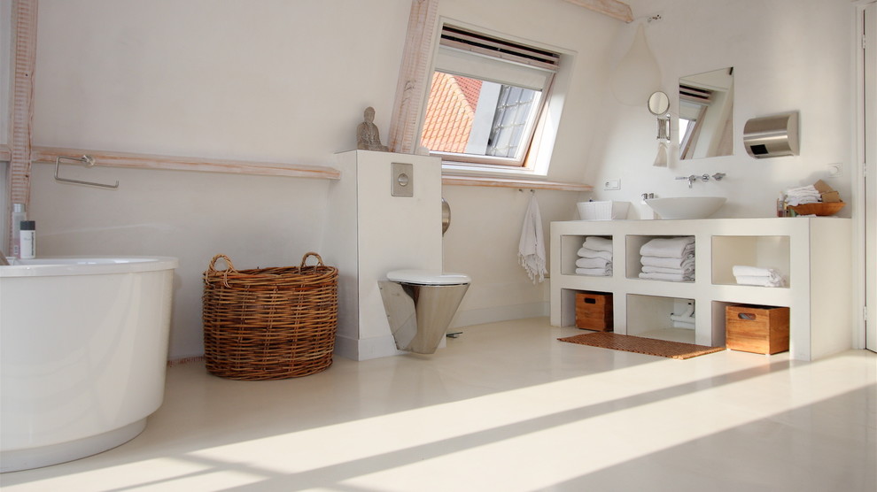 This is an example of a mid-sized contemporary bathroom in Dortmund with open cabinets, white cabinets, a freestanding tub, a wall-mount toilet, white walls and a vessel sink.