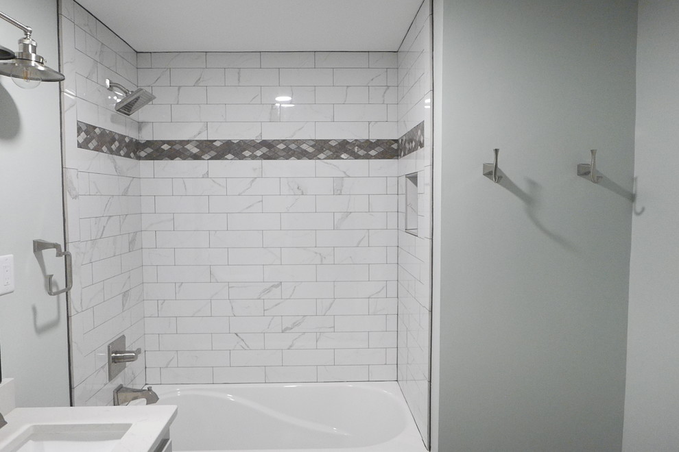 Alcove bathtub - mid-sized transitional kids' white tile and porcelain tile porcelain tile and gray floor alcove bathtub idea with shaker cabinets, gray cabinets, a two-piece toilet, green walls, an undermount sink, quartz countertops and white countertops