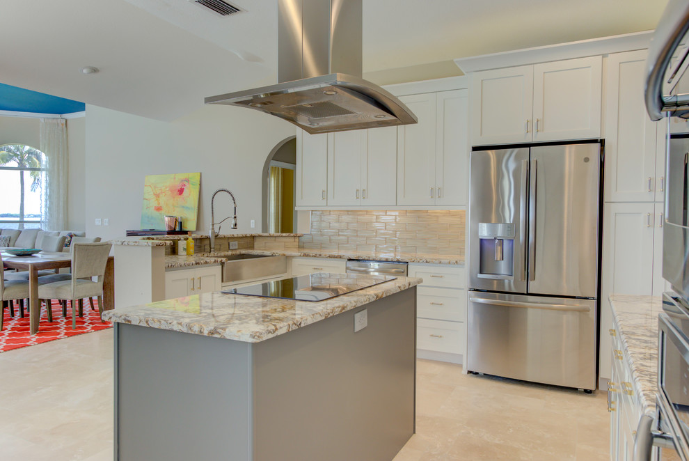 Photo of a large contemporary u-shaped eat-in kitchen in Miami with a farmhouse sink, shaker cabinets, white cabinets, granite benchtops, beige splashback, glass tile splashback, stainless steel appliances, with island, beige floor and beige benchtop.