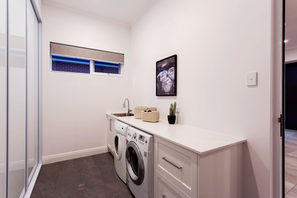 Mid-sized traditional galley dedicated laundry room in Adelaide with a drop-in sink, white walls, porcelain floors, a side-by-side washer and dryer, grey floor, beaded inset cabinets and white cabinets.