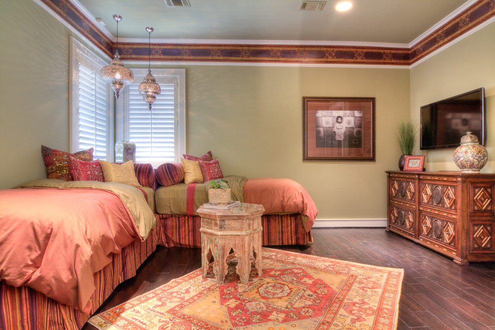 This is an example of a mediterranean guest bedroom in Houston with green walls, dark hardwood floors and no fireplace.