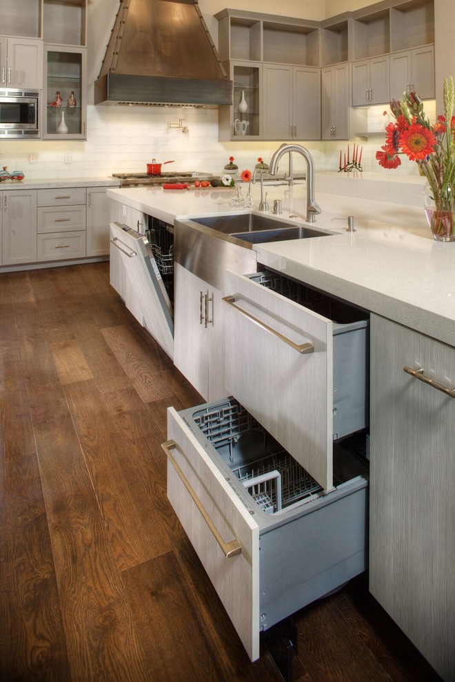 Eat-in kitchen - large transitional u-shaped medium tone wood floor eat-in kitchen idea in Sacramento with a farmhouse sink, flat-panel cabinets, white cabinets, solid surface countertops, white backsplash, subway tile backsplash, stainless steel appliances and an island