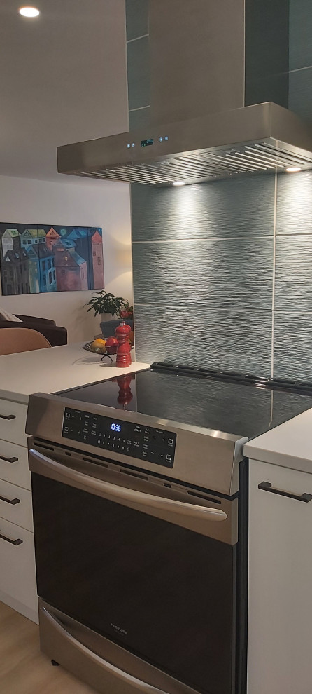 Photo of a small bohemian u-shaped open plan kitchen in Ottawa with a submerged sink, flat-panel cabinets, white cabinets, engineered stone countertops, blue splashback, porcelain splashback, stainless steel appliances, vinyl flooring, a breakfast bar, beige floors and white worktops.