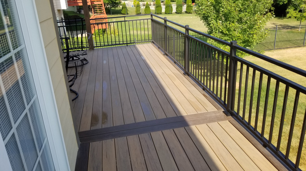 Cette photo montre une terrasse arrière et au premier étage de taille moyenne avec des solutions pour vis-à-vis, une extension de toiture et un garde-corps en métal.