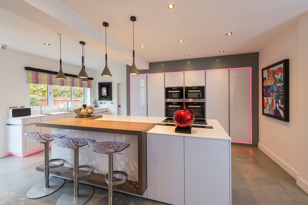 This is an example of a large contemporary u-shaped eat-in kitchen in West Midlands with an undermount sink, flat-panel cabinets, white cabinets, white splashback and a peninsula.