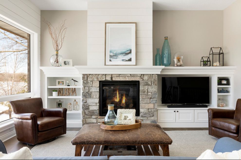 Photo of a mid-sized transitional formal living room in Minneapolis with beige walls, medium hardwood floors, a standard fireplace, a stone fireplace surround and brown floor.