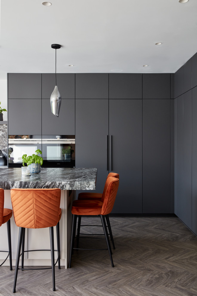 Design ideas for a large contemporary l-shaped kitchen/diner in London with flat-panel cabinets, black cabinets and an island.