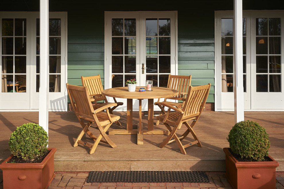 Mittelgroße, Überdachte Landhausstil Terrasse hinter dem Haus mit Kübelpflanzen in Sonstige