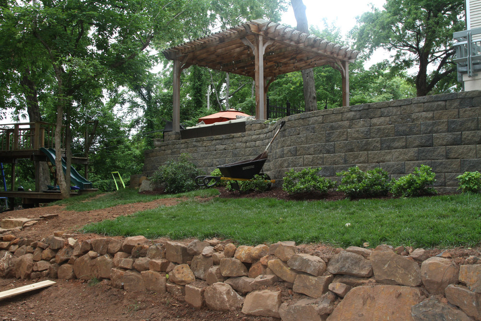 Photo of a large arts and crafts sloped outdoor sport court in Other with a retaining wall and natural stone pavers.