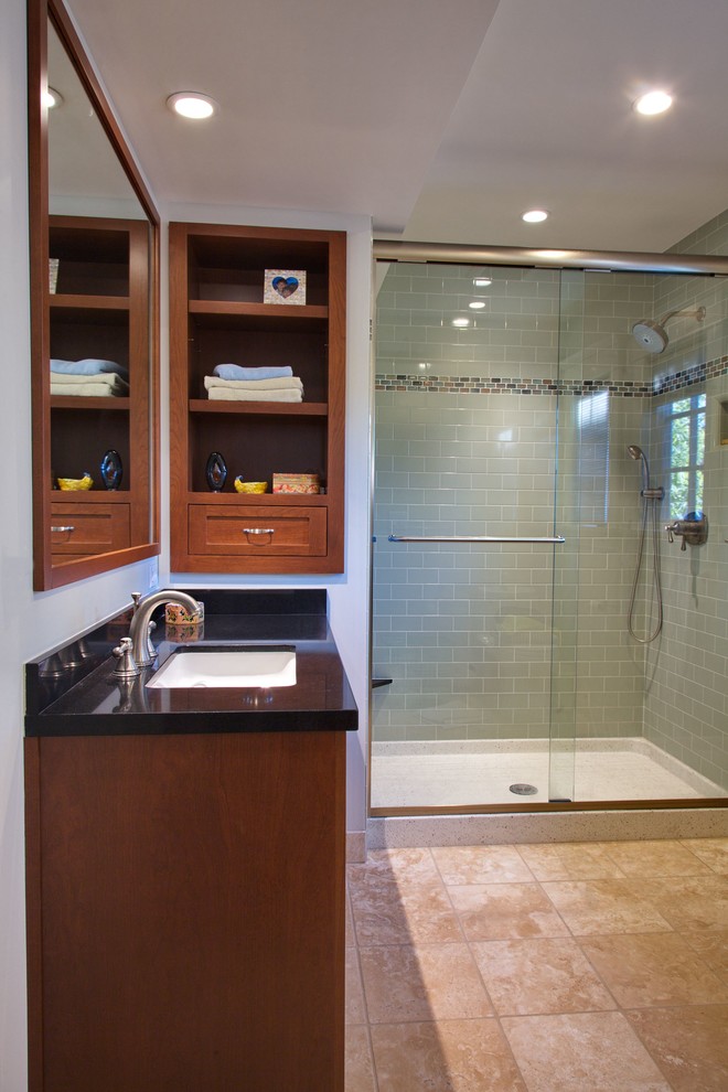 Photo of a mid-sized contemporary 3/4 bathroom in San Francisco with shaker cabinets, medium wood cabinets, an alcove shower, green tile, subway tile, white walls, limestone floors, an undermount sink, engineered quartz benchtops, beige floor, a sliding shower screen and black benchtops.