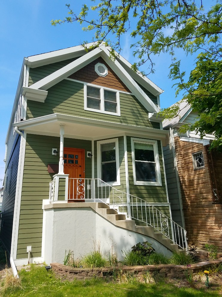 This is an example of a mid-sized traditional three-storey green house exterior in Chicago with concrete fiberboard siding, a shingle roof and a gable roof.