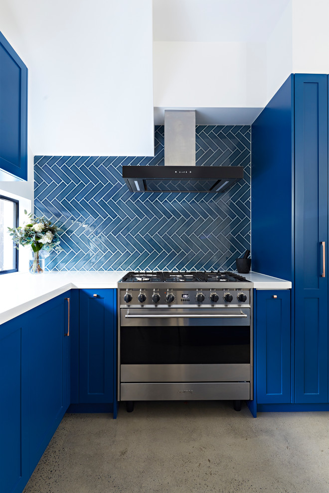 Inspiration for a mid-sized transitional l-shaped kitchen pantry in Melbourne with a double-bowl sink, shaker cabinets, blue cabinets, blue splashback, ceramic splashback, stainless steel appliances, concrete floors, with island, grey floor, white benchtop and quartz benchtops.