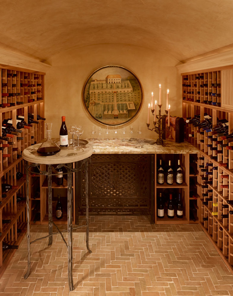 Design ideas for a mid-sized mediterranean wine cellar in Santa Barbara with terra-cotta floors, storage racks and beige floor.