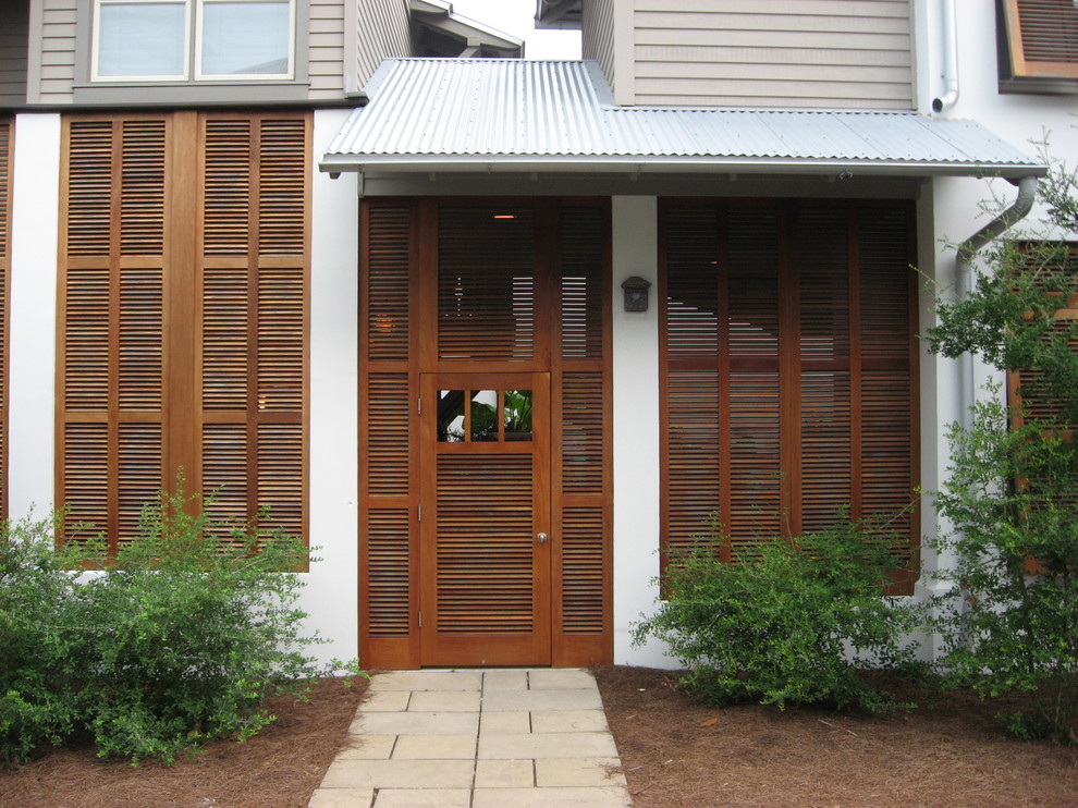 Design ideas for a tropical entryway in New Orleans with a single front door.