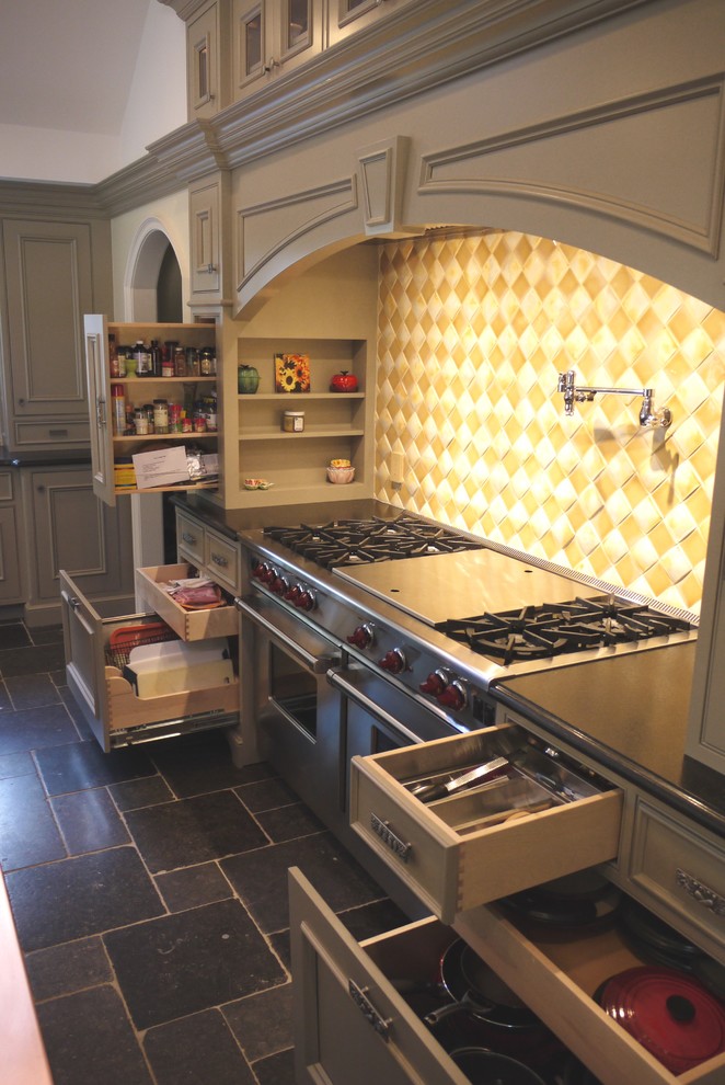 Inspiration for a large traditional l-shaped eat-in kitchen in Newark with an undermount sink, recessed-panel cabinets, beige cabinets, copper benchtops, yellow splashback, glass tile splashback, stainless steel appliances, slate floors and with island.