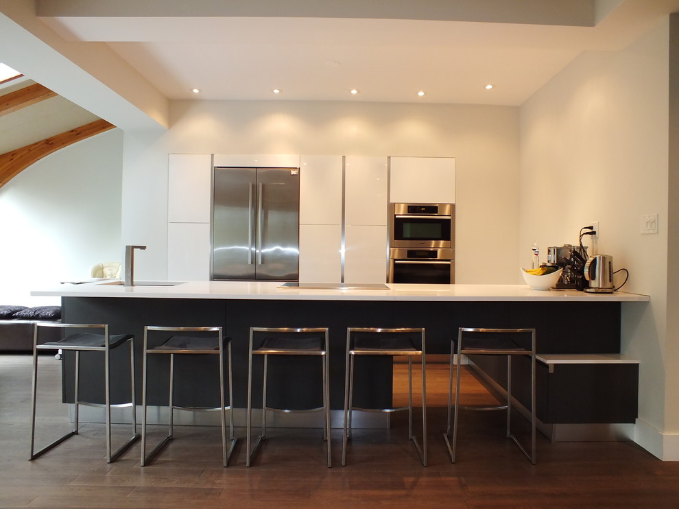 Inspiration for a mid-sized modern l-shaped separate kitchen in Montreal with stainless steel appliances, an undermount sink, flat-panel cabinets, white cabinets, solid surface benchtops, dark hardwood floors and with island.