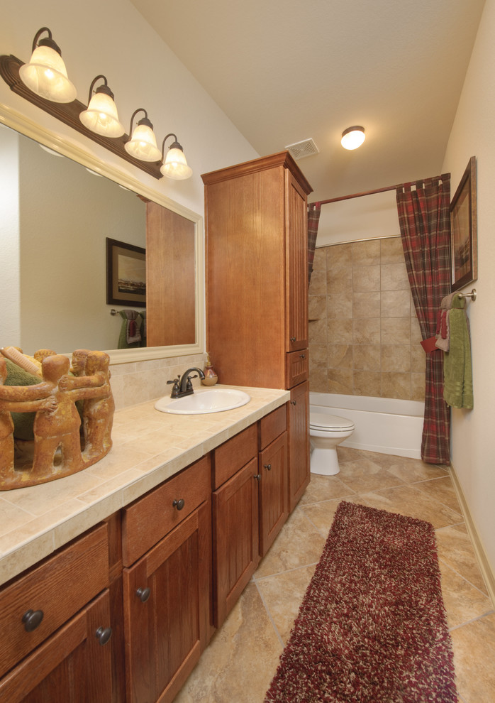 Small transitional master bathroom in Houston with recessed-panel cabinets, medium wood cabinets, an alcove tub, a shower/bathtub combo, a two-piece toilet, travertine, white walls, travertine floors, a drop-in sink, terrazzo benchtops, beige floor, a shower curtain and beige benchtops.