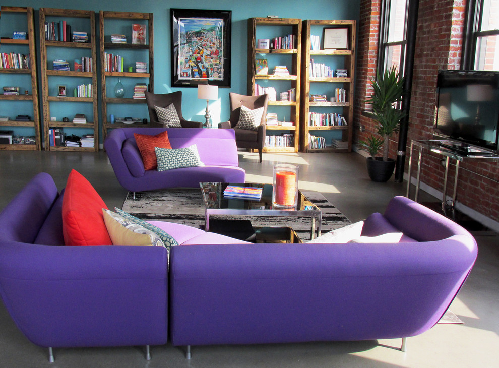 Aménagement d'un grand salon mansardé ou avec mezzanine contemporain avec une bibliothèque ou un coin lecture, un mur bleu, sol en béton ciré et un téléviseur indépendant.