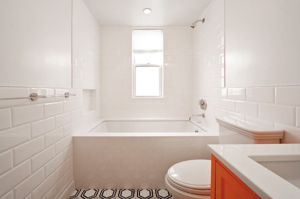 Small transitional 3/4 bathroom in New York with recessed-panel cabinets, orange cabinets, an alcove tub, an alcove shower, a two-piece toilet, white tile, ceramic tile, white walls, marble floors, an undermount sink, quartzite benchtops, grey floor and a shower curtain.