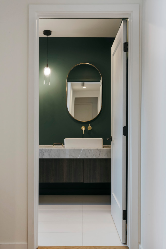 Идея дизайна: туалет в стиле ретро с плоскими фасадами, коричневыми фасадами, унитазом-моноблоком, зелеными стенами, полом из керамогранита, настольной раковиной, мраморной столешницей, белым полом, белой столешницей и подвесной тумбой