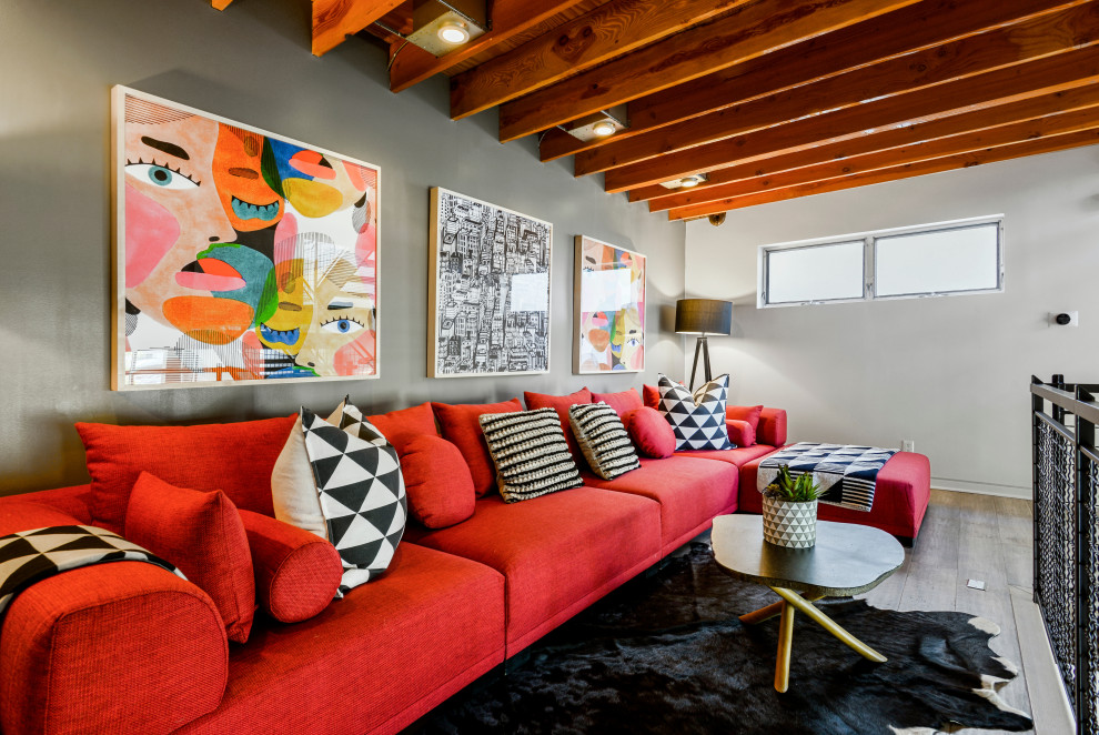 This is an example of an industrial loft-style family room in Los Angeles with grey walls and exposed beam.