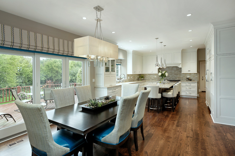 This is an example of a large transitional l-shaped eat-in kitchen in Chicago with an undermount sink, recessed-panel cabinets, white cabinets, granite benchtops, beige splashback, glass tile splashback, stainless steel appliances, medium hardwood floors, with island and brown floor.
