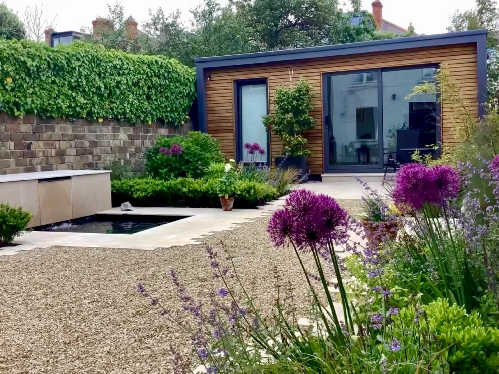 Photo of a small contemporary garden in Other with with path, natural stone pavers and a wood fence.