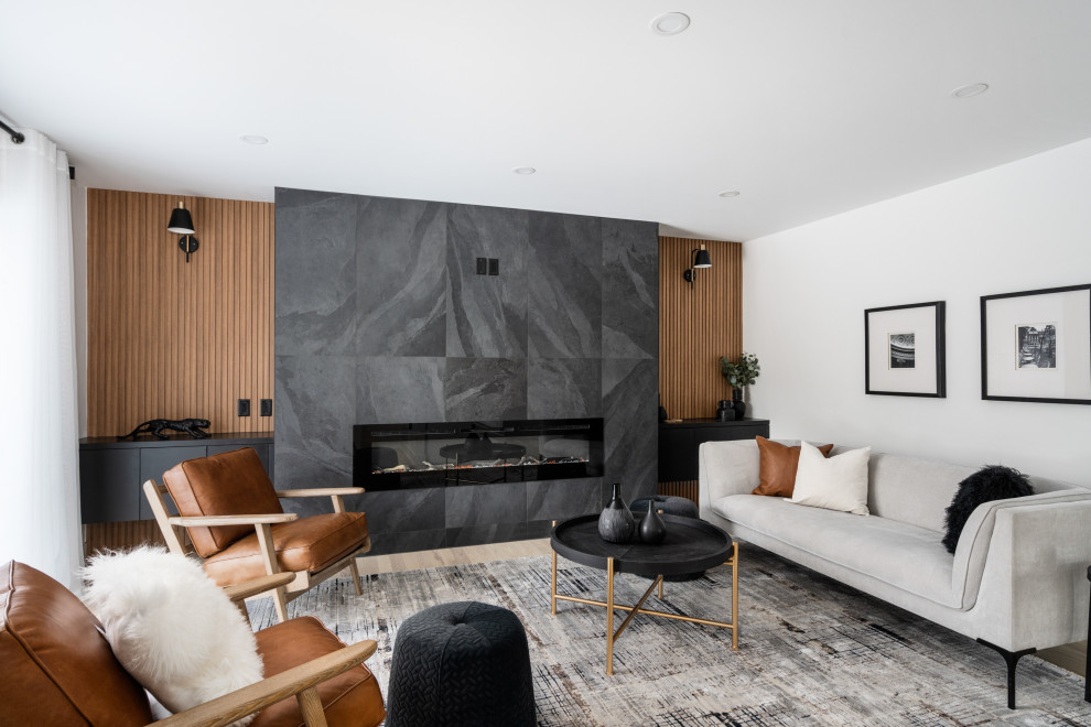 Mittelgroßes, Abgetrenntes Modernes Wohnzimmer mit weißer Wandfarbe, hellem Holzboden, Kamin, gefliester Kaminumrandung, Multimediawand, beigem Boden und Holzwänden in Montreal