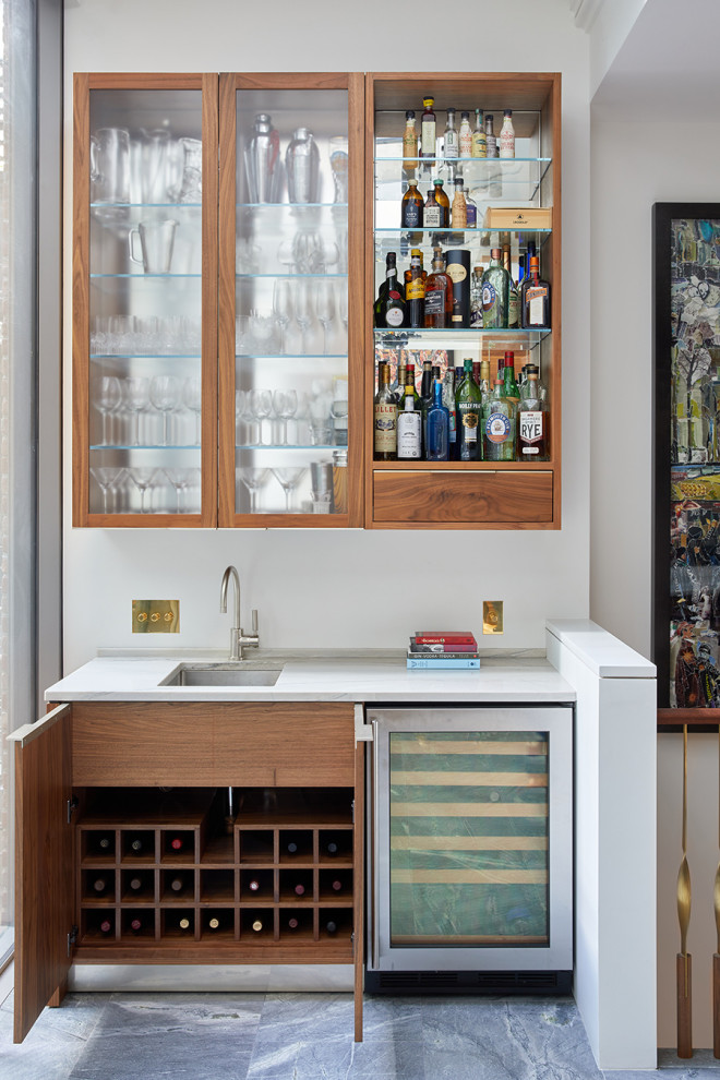 Foto di un angolo bar con lavandino moderno con ante in legno chiaro e top bianco