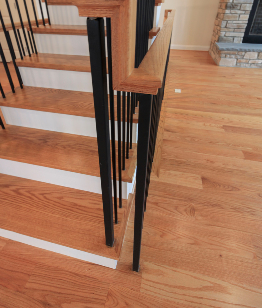 Стильный дизайн: большая деревянная лестница на больцах в стиле неоклассика (современная классика) с деревянными ступенями, перилами из смешанных материалов и стенами из вагонки - последний тренд