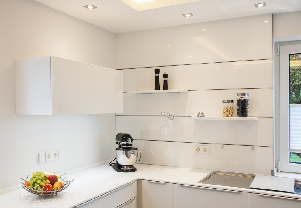 Inspiration for a small contemporary u-shaped separate kitchen in Bremen with a drop-in sink, flat-panel cabinets, white cabinets, granite benchtops, white splashback, window splashback, stainless steel appliances, cement tiles, no island and beige floor.