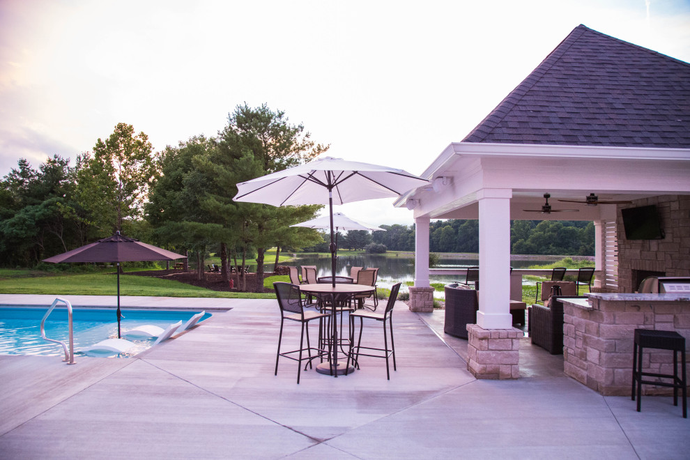 Ejemplo de piscinas y jacuzzis de estilo americano grandes rectangulares en patio trasero con losas de hormigón