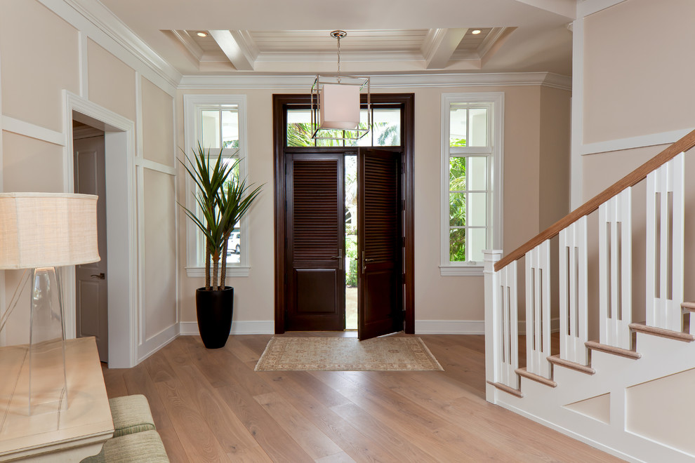Example of a mid-sized transitional medium tone wood floor front door design in Miami with beige walls and a dark wood front door