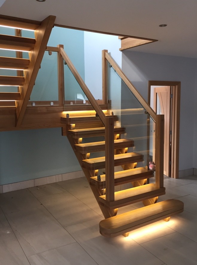Mid-sized contemporary wood u-shaped staircase in Other with glass railing.