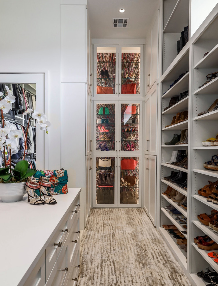 Transitional women's walk-in wardrobe in Austin with white cabinets and multi-coloured floor.