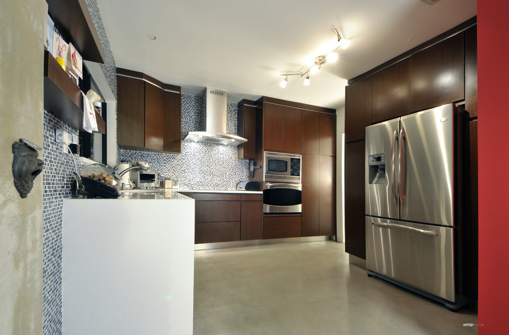 Photo of a mid-sized contemporary galley open plan kitchen in Miami with an undermount sink, flat-panel cabinets, dark wood cabinets, quartz benchtops, white splashback, mosaic tile splashback, stainless steel appliances, concrete floors and with island.