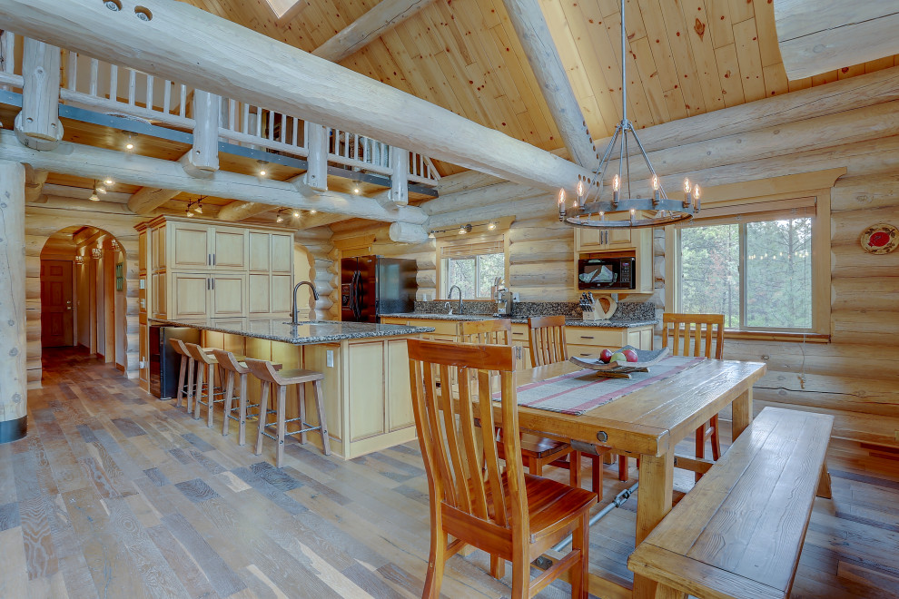 Large country open plan dining in Other with brown walls, brown floor and laminate floors.