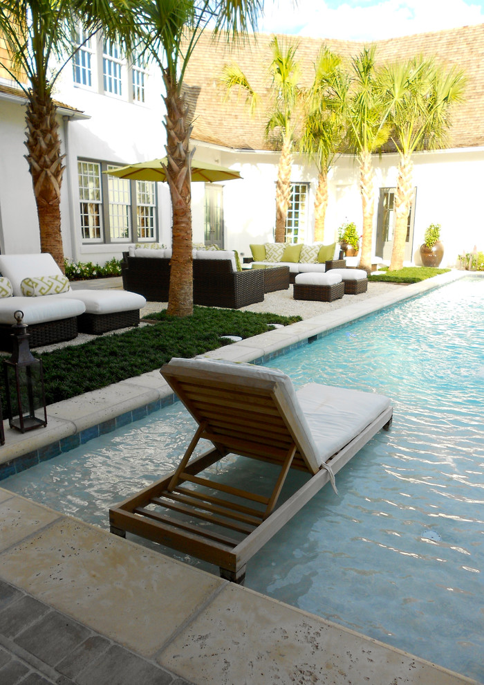 Inspiration for a large contemporary backyard rectangular lap pool in Miami with concrete pavers.