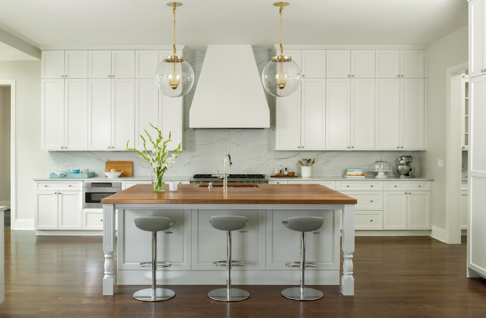Example of a transitional galley dark wood floor and brown floor kitchen design in Denver with an undermount sink, shaker cabinets, white cabinets, gray backsplash, stainless steel appliances, an island and gray countertops