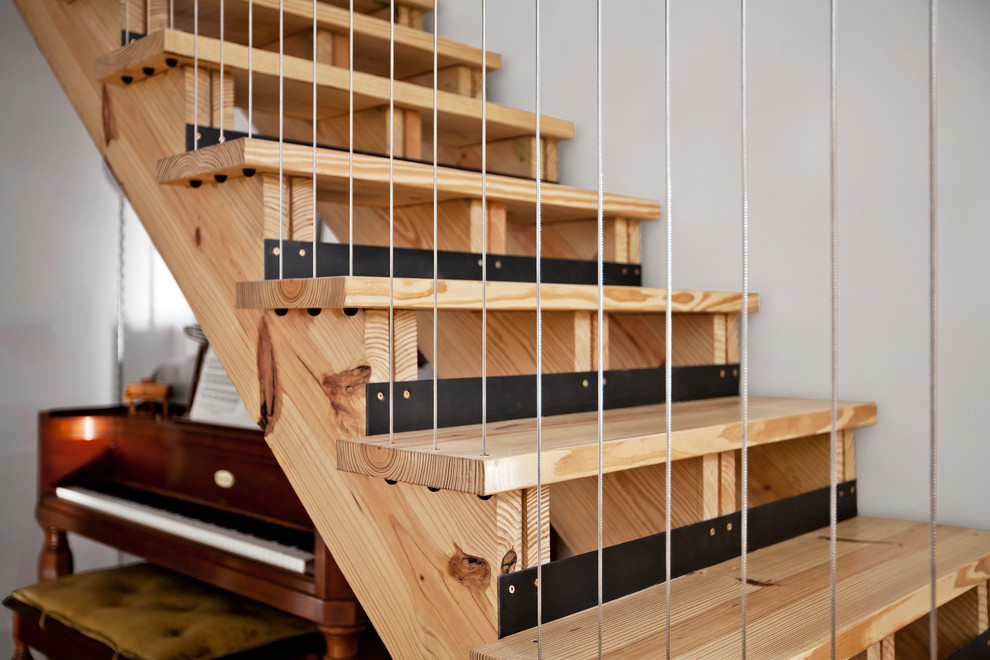Inspiration for a mid-sized transitional wood straight staircase in Indianapolis with cable railing and open risers.