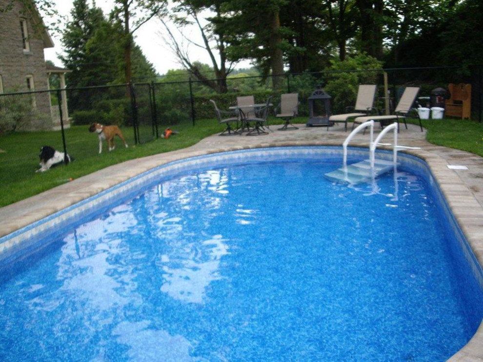 Example of a transitional courtyard tile and round pool design in Toronto
