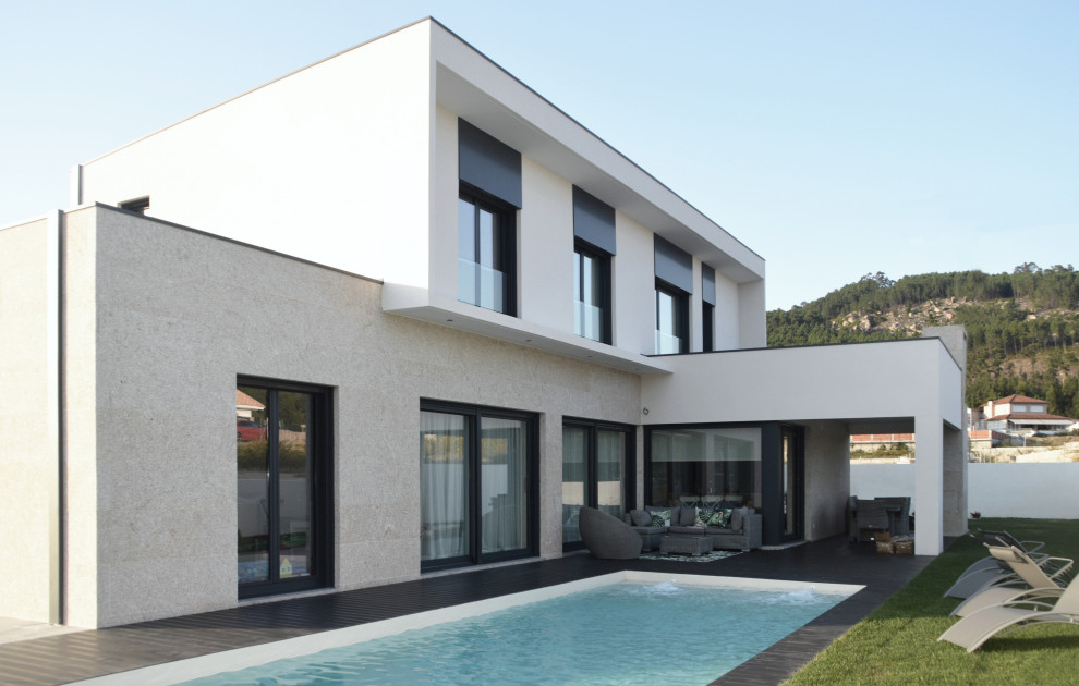 Ispirazione per la villa grande bianca moderna a due piani con tetto piano, rivestimento in pietra, copertura mista e tetto bianco