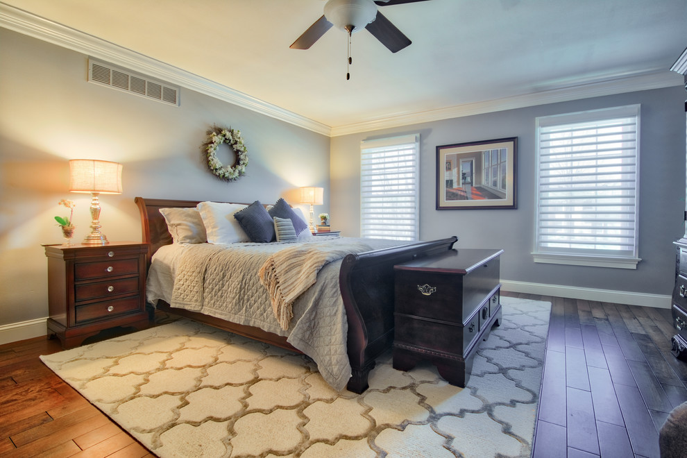 Design ideas for a large classic master bedroom in Philadelphia with blue walls, medium hardwood flooring, a standard fireplace, a metal fireplace surround and brown floors.