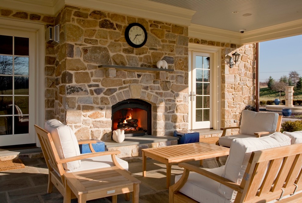 This is an example of a traditional patio in Philadelphia with natural stone pavers and a fire feature.