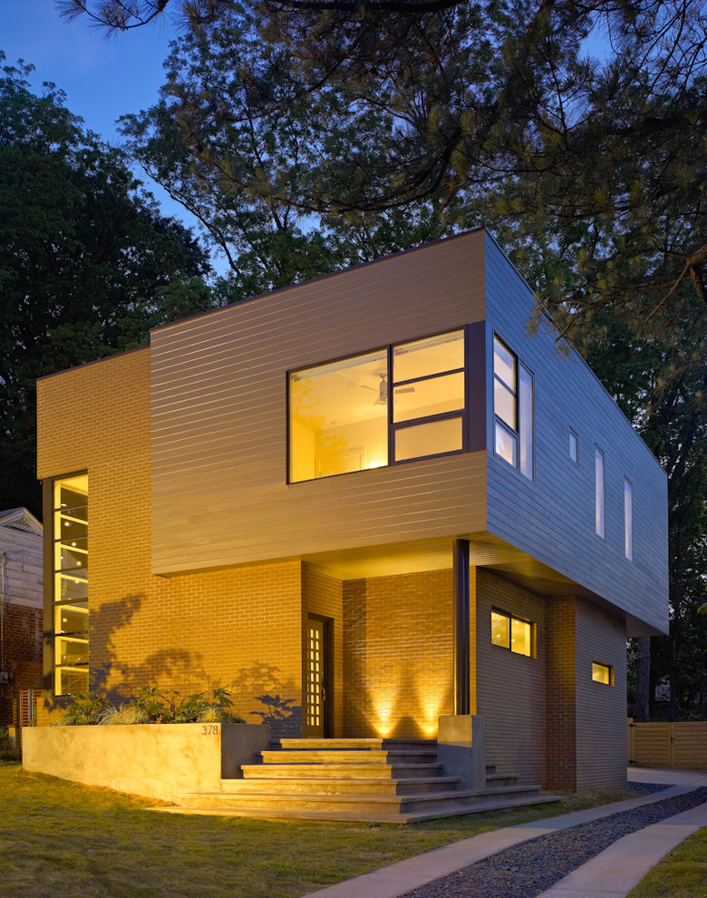 This is an example of a mid-sized modern two-storey brown house exterior in Atlanta with mixed siding and a flat roof.