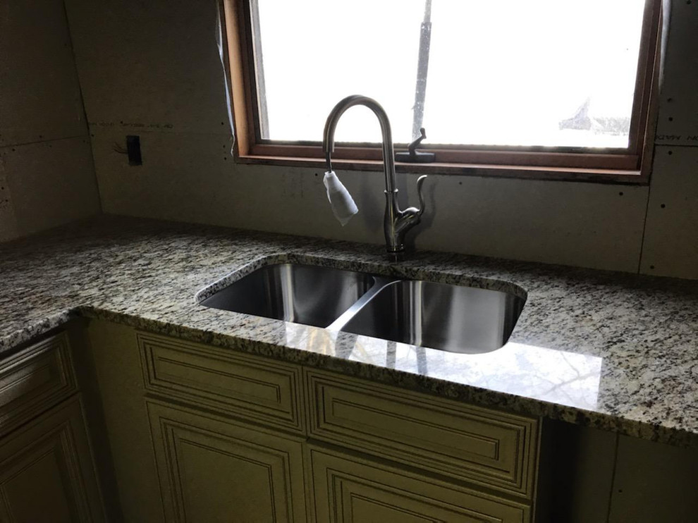 Mid-sized u-shaped enclosed kitchen photo with a double-bowl sink, raised-panel cabinets, beige cabinets, granite countertops, stainless steel appliances, a peninsula and beige countertops
